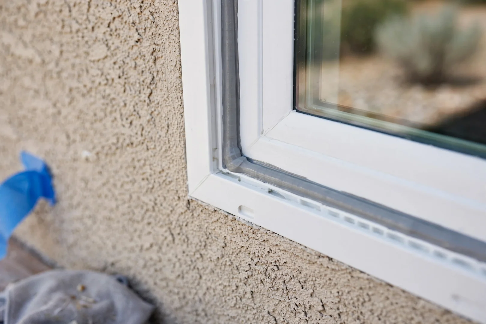 Close-up of exterior sealant bead along a new picture window frame